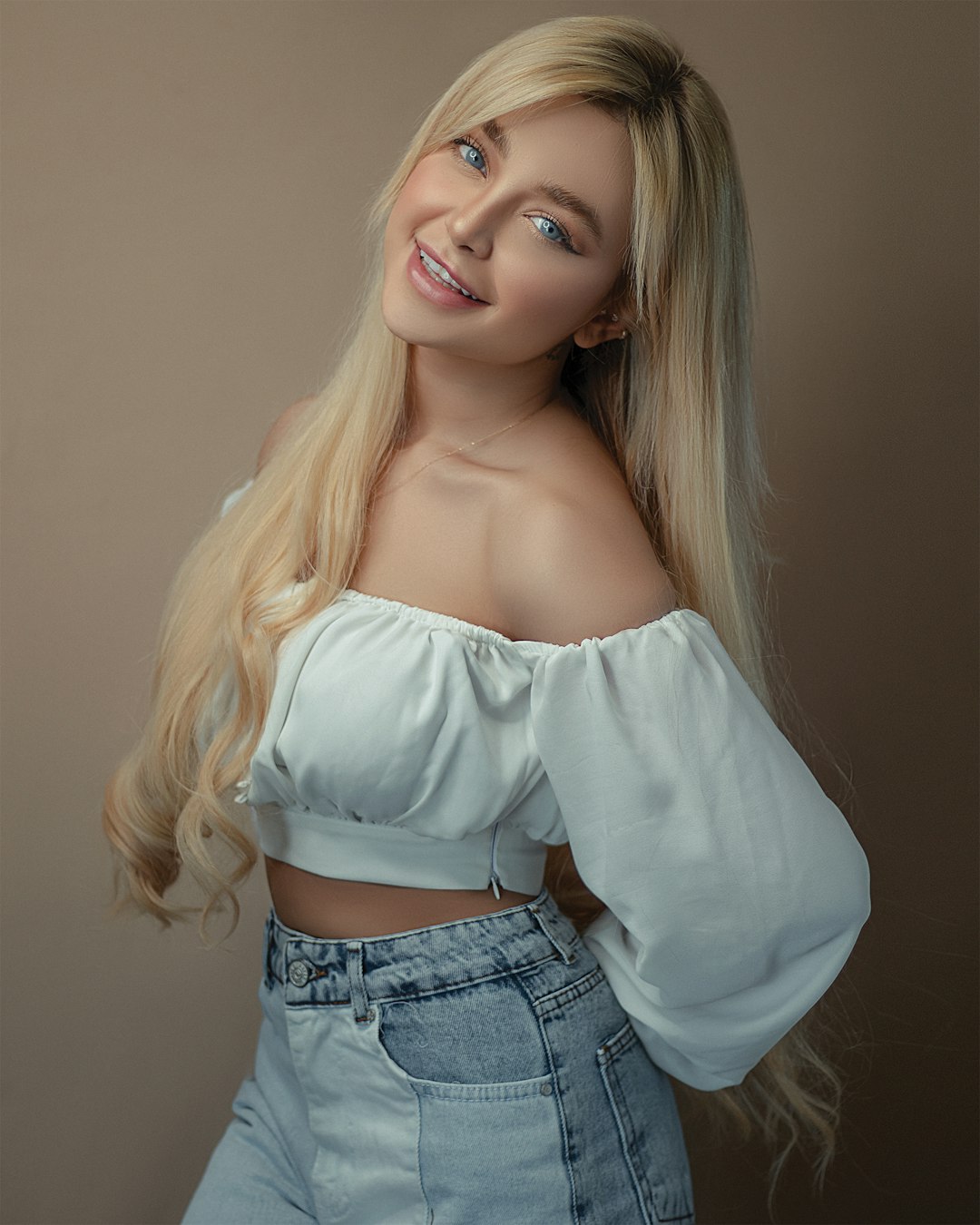 woman in white off shoulder long sleeve shirt and blue denim jeans