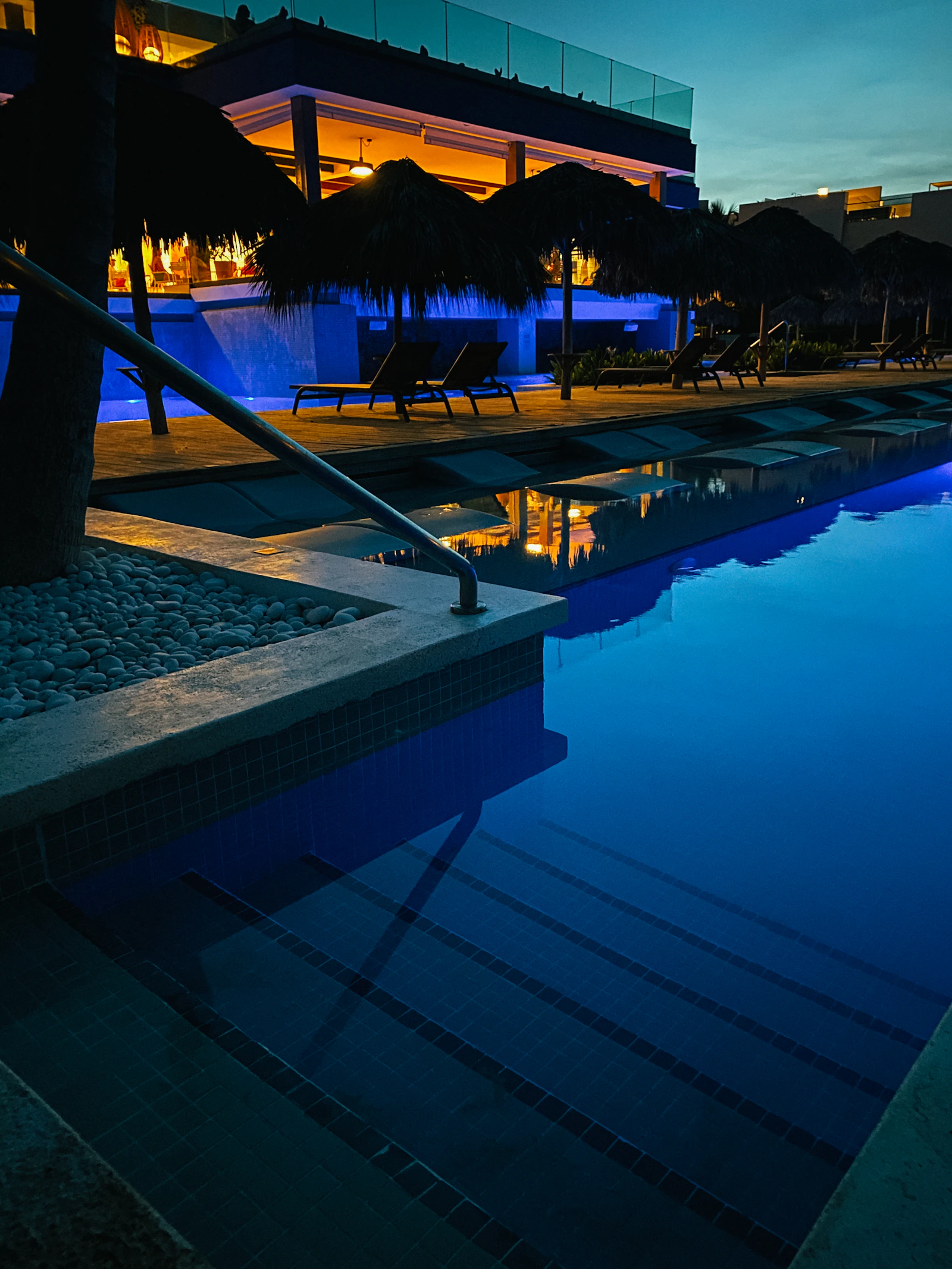 Fotografía nocturna de piscina con iluminación perimetral