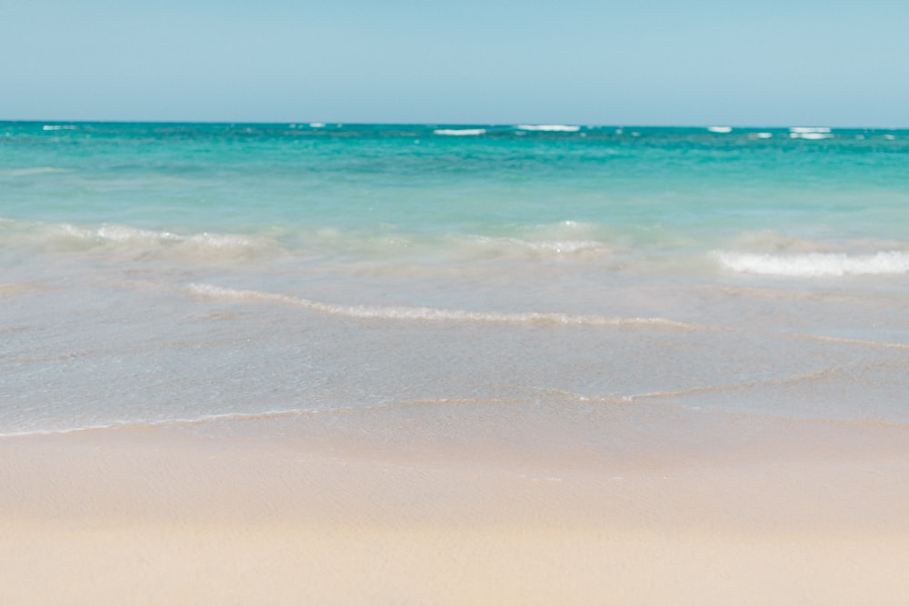 sea waves crashing on shore during daytime