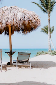 brown and white beach chair near beach during daytime