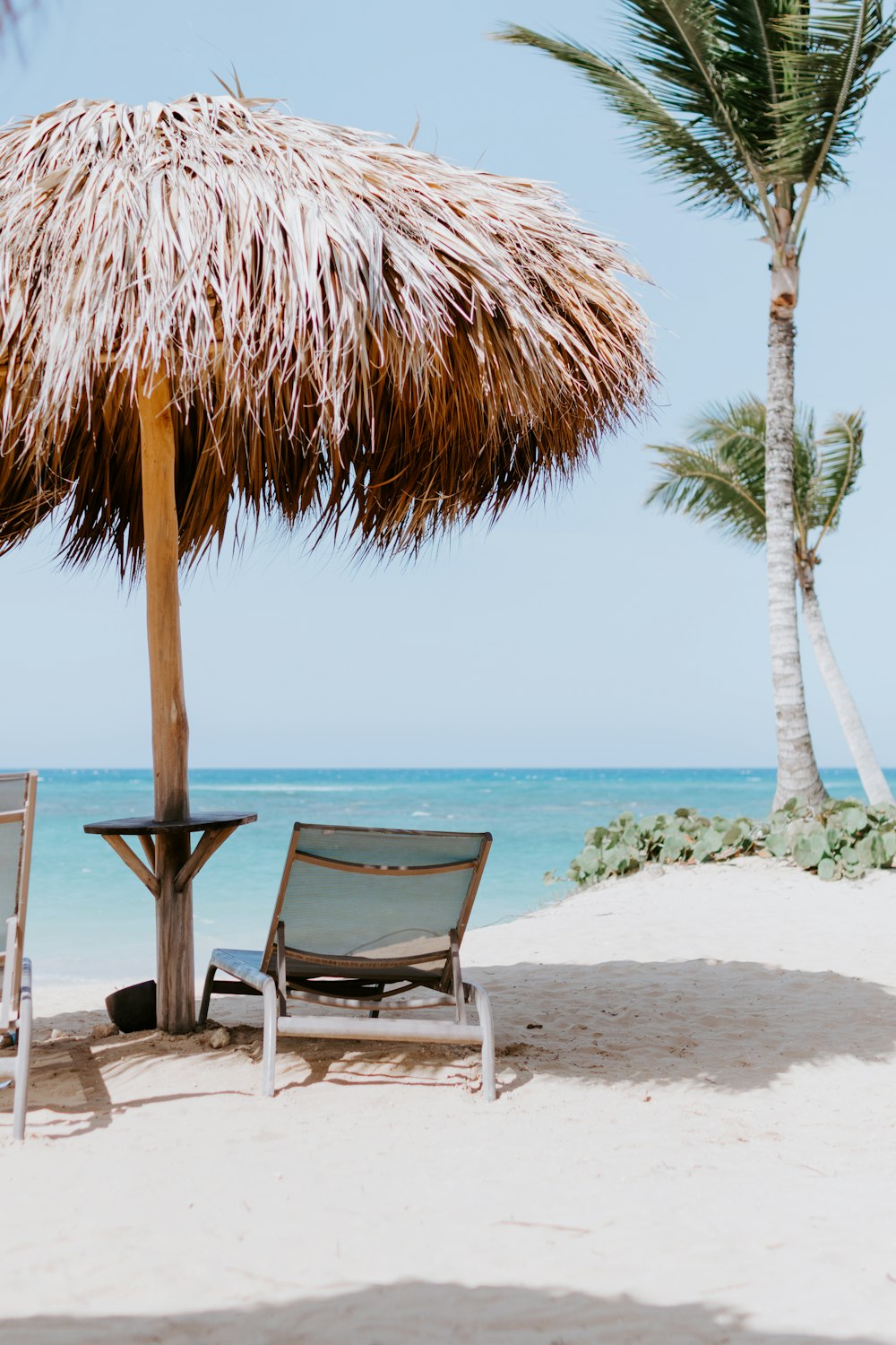 brown and white beach chair near beach during daytime