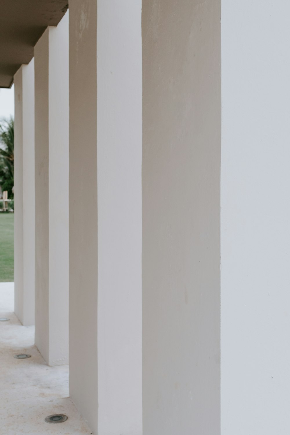 white concrete pillar near green grass field during daytime