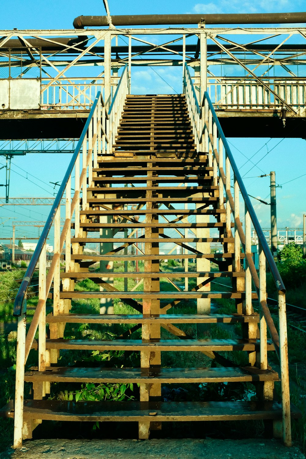 brown wooden bridge over green grass field during daytime