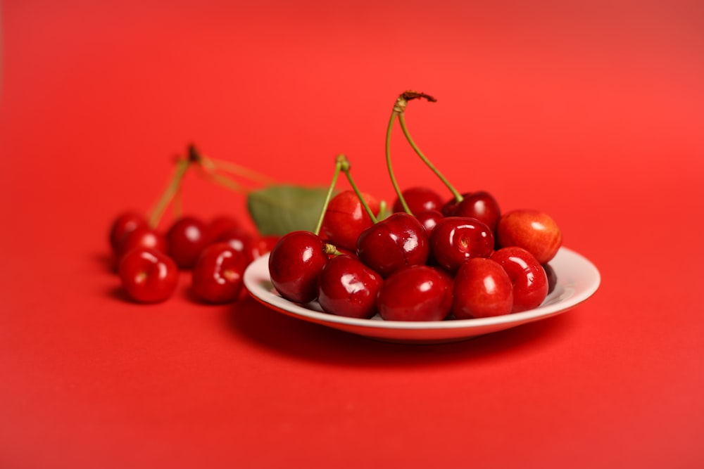 red cherry fruits on white ceramic bowl