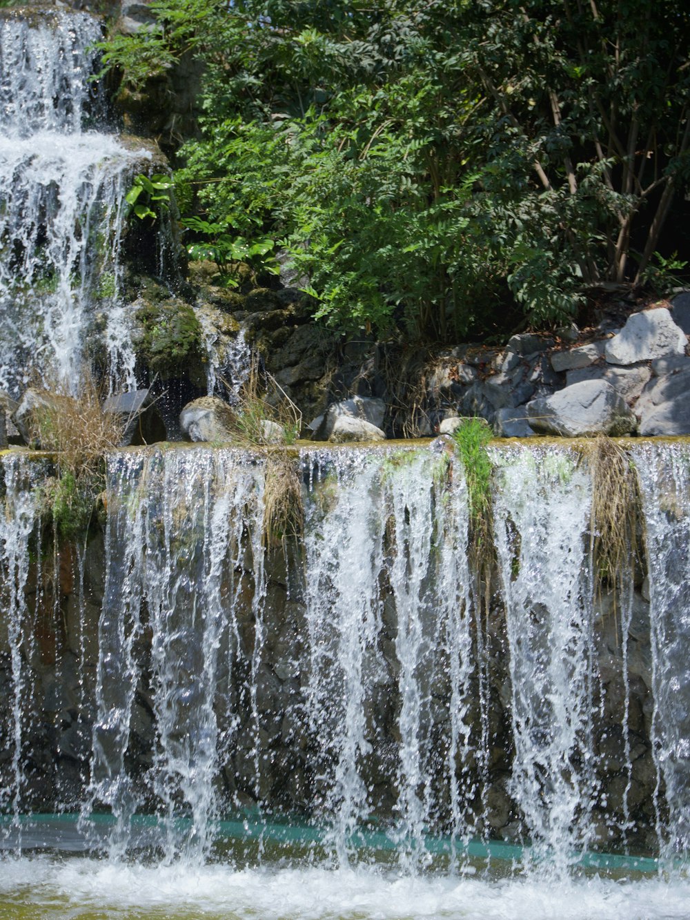 water falls on rocky shore during daytime