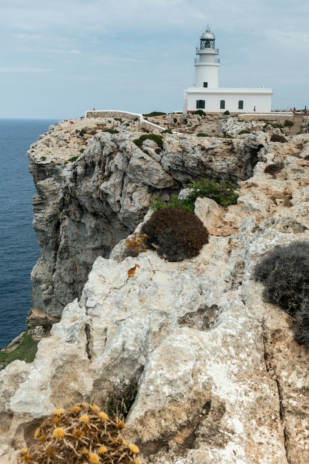 white concrete building on cliff by the sea