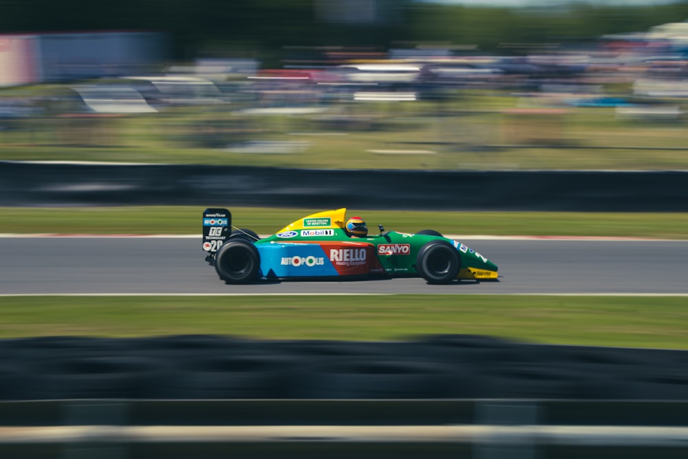 blue and yellow f 1 car on road