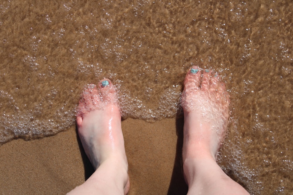 person with red pedicure on brown textile