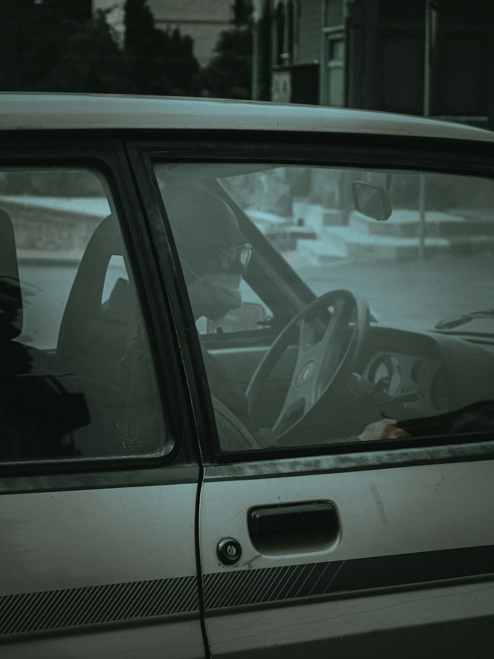 Persona con chaqueta negra conduciendo coche