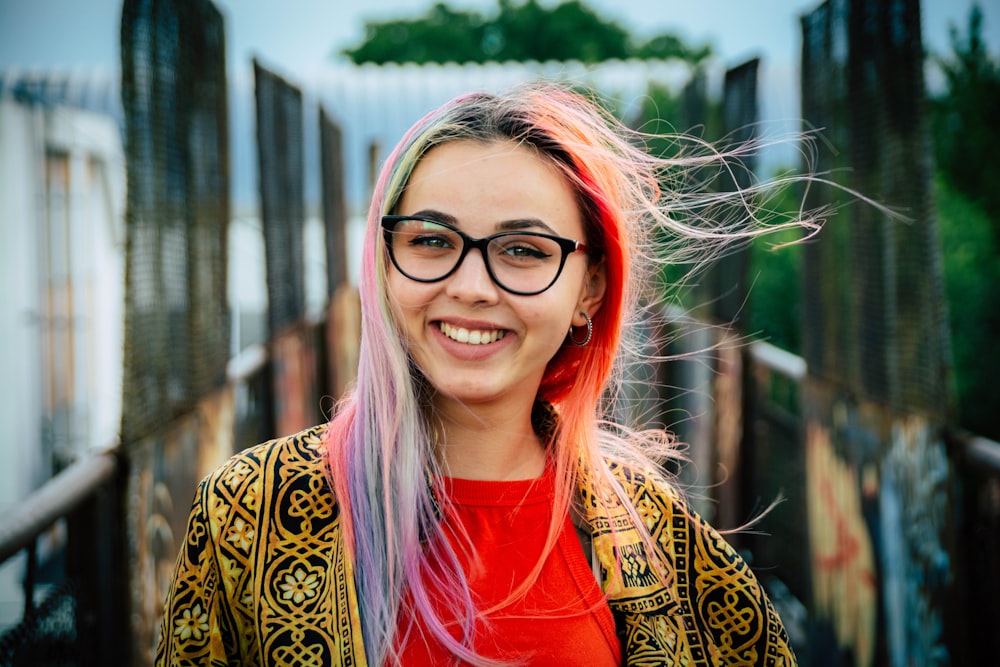 woman in red crew neck shirt and brown and black leopard print cardigan smiling