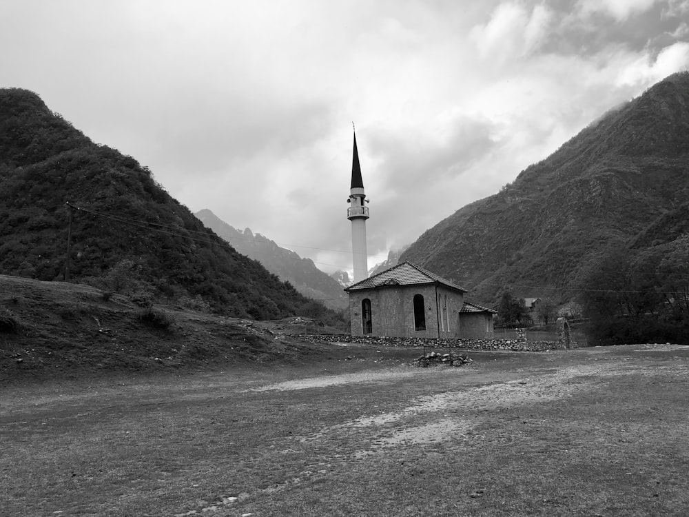 grayscale photo of concrete building near mountain