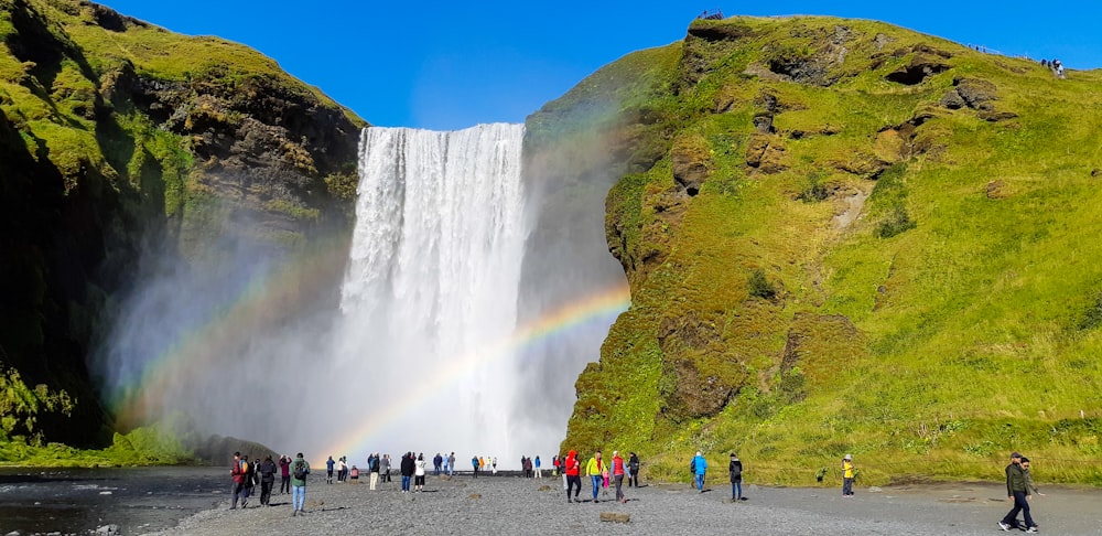 people standing near waterfalls during daytime