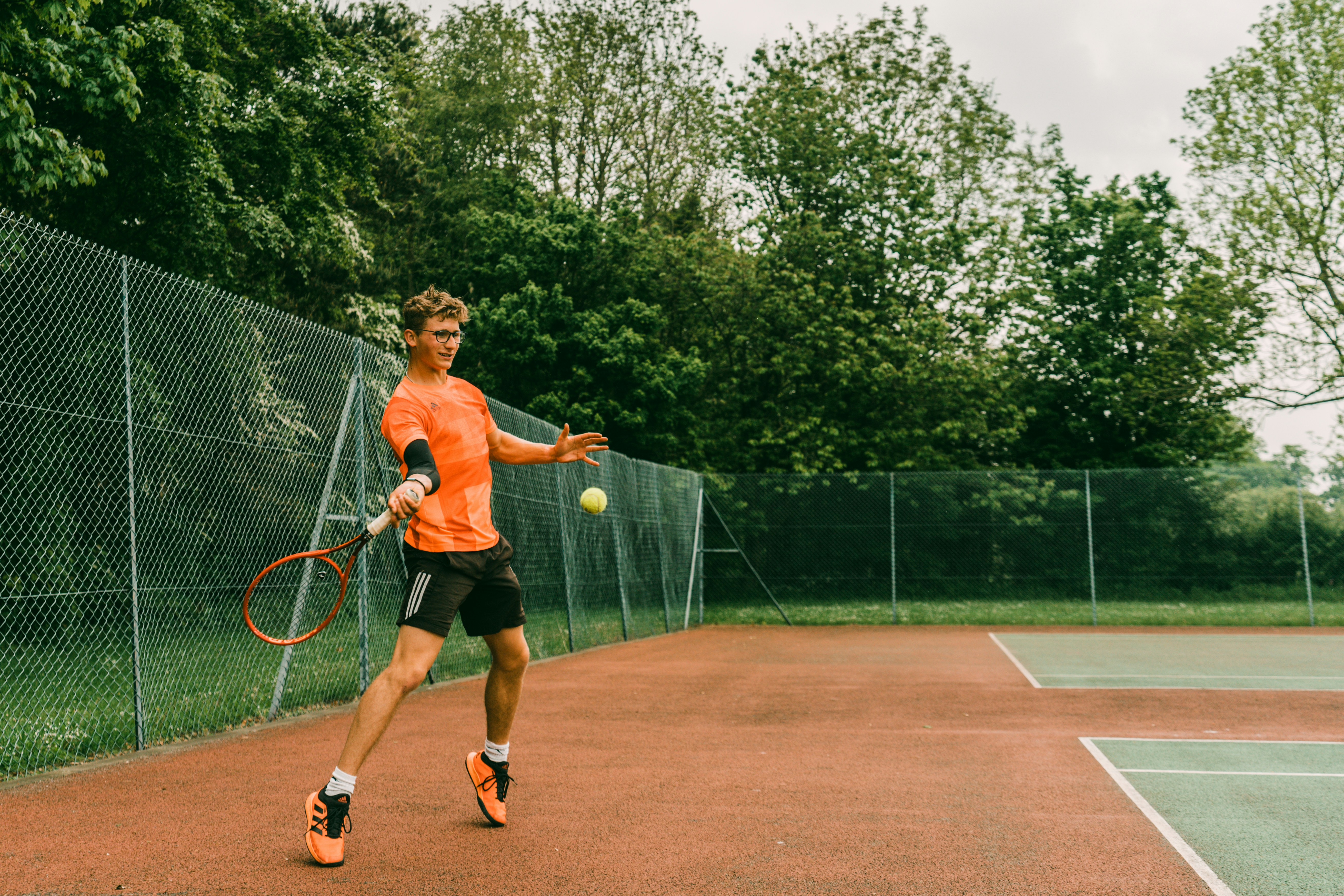 woman in black tank top playing tennis during daytime, 
