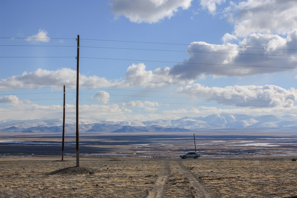 black metal fence on brown sand under white clouds and blue sky during daytime