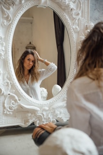 A serene setting with a full-length mirror reflecting a joyful woman.