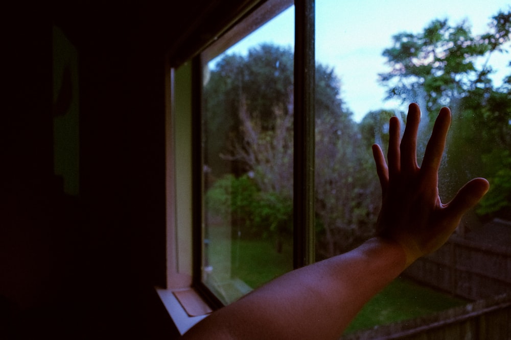 persons hand near window