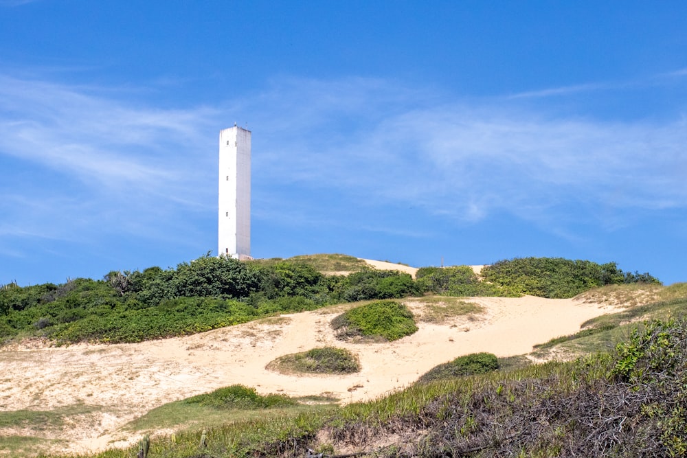 torre di cemento bianco su campo marrone sotto cielo blu durante il giorno