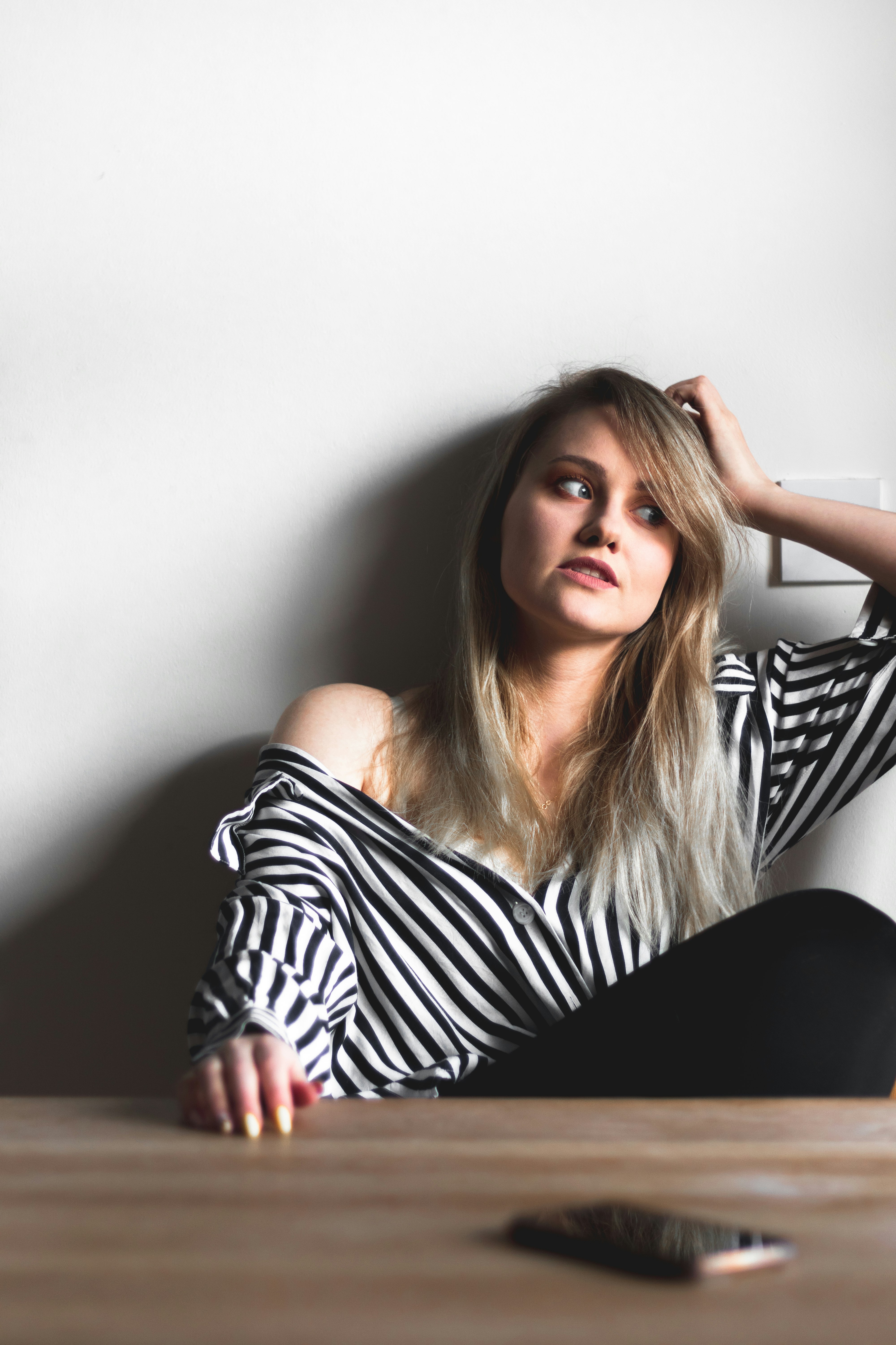 woman in black and white striped off shoulder shirt sitting on black chair