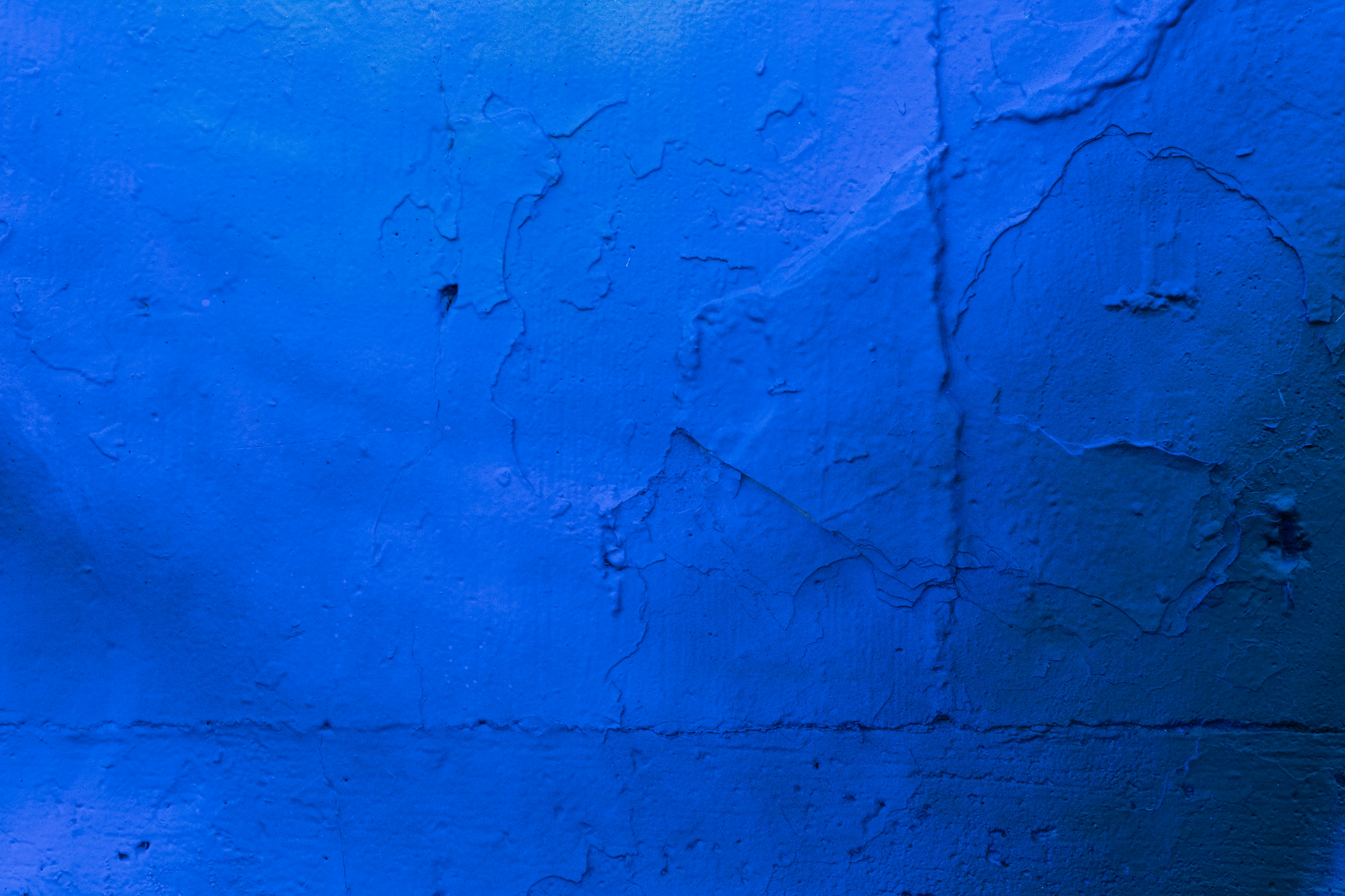 royal blue textured wall with cracks and crevices