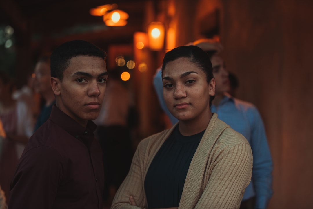 man in gray dress shirt standing beside man in black jacket