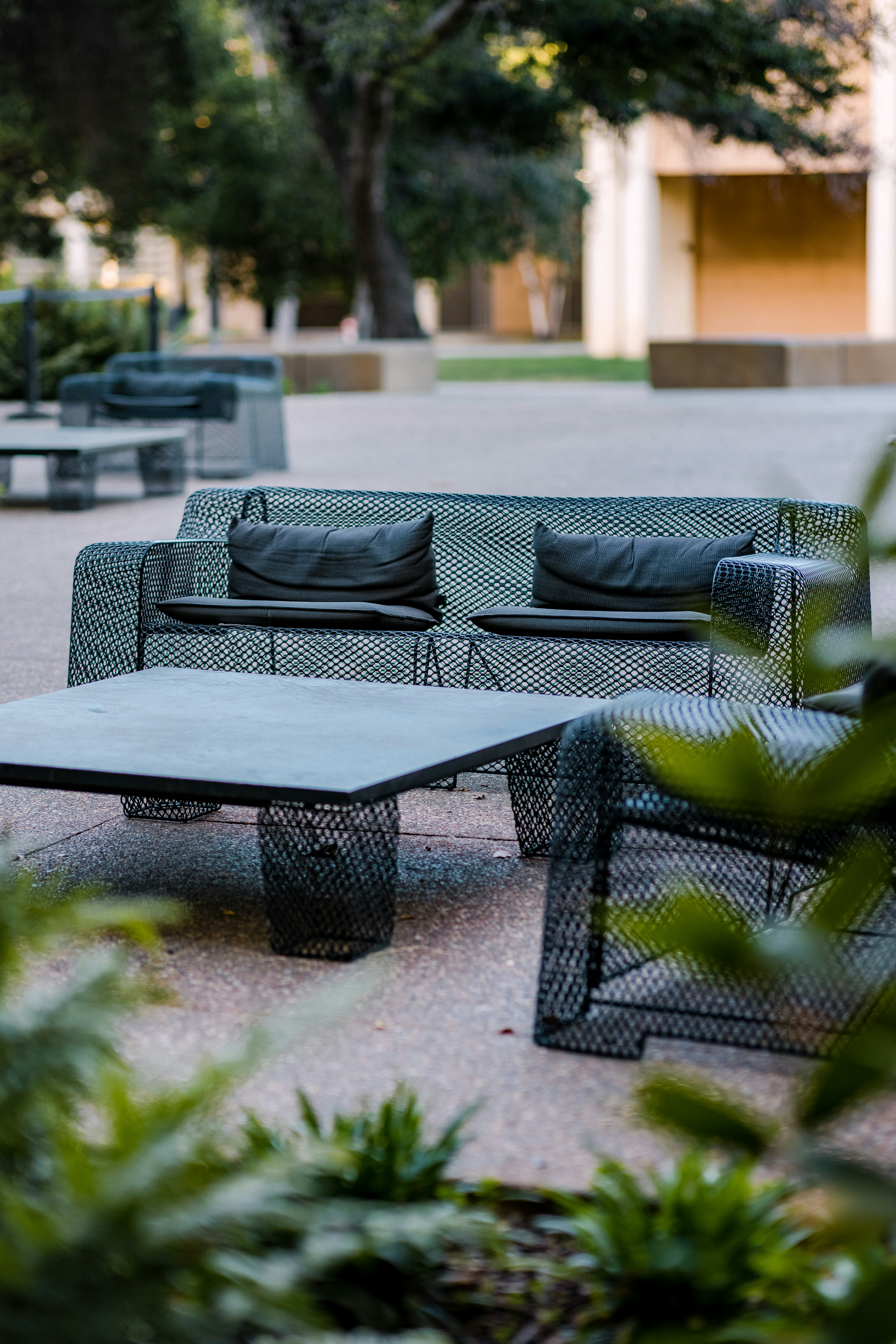 Black wooden outdoor table with green chairs at a beach club terrace