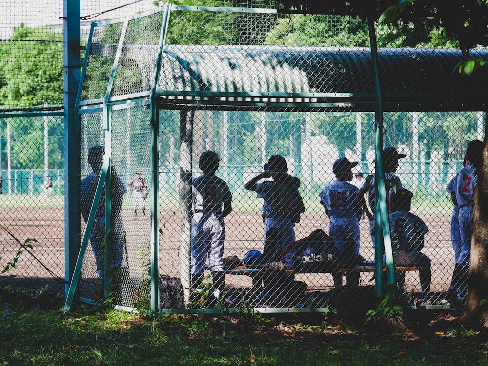 people standing near white metal fence during daytime