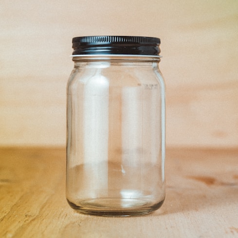 clear glass jar sitting on a wooden surface