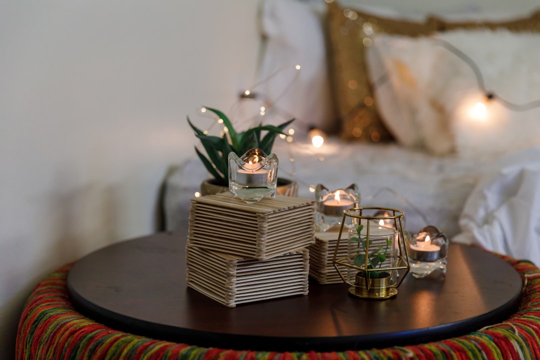 green plant on brown wooden table, a cozy boho room decor with candles and string lights
