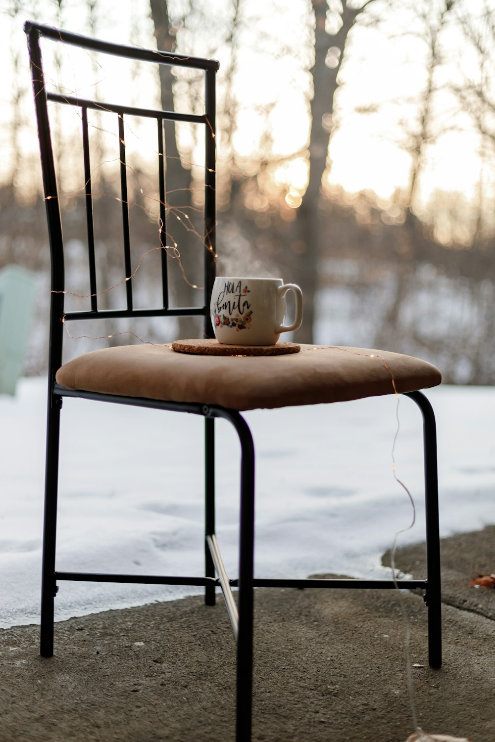 weiße Keramiktasse auf braunem Holzstuhl