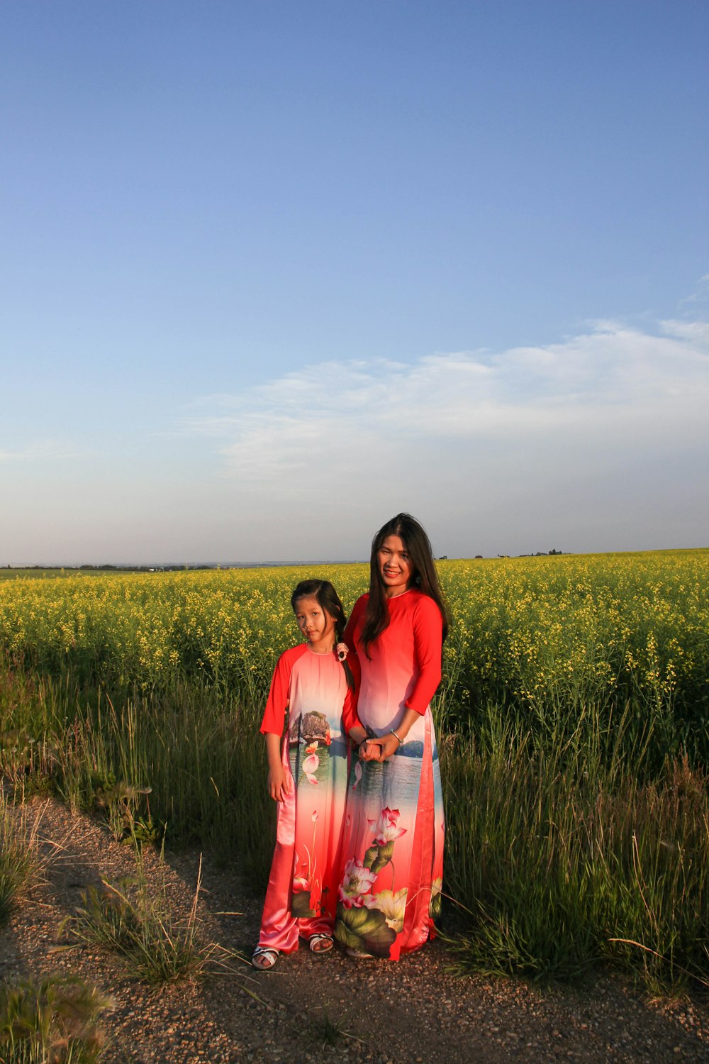 woman in red dress standing on green grass field during daytime