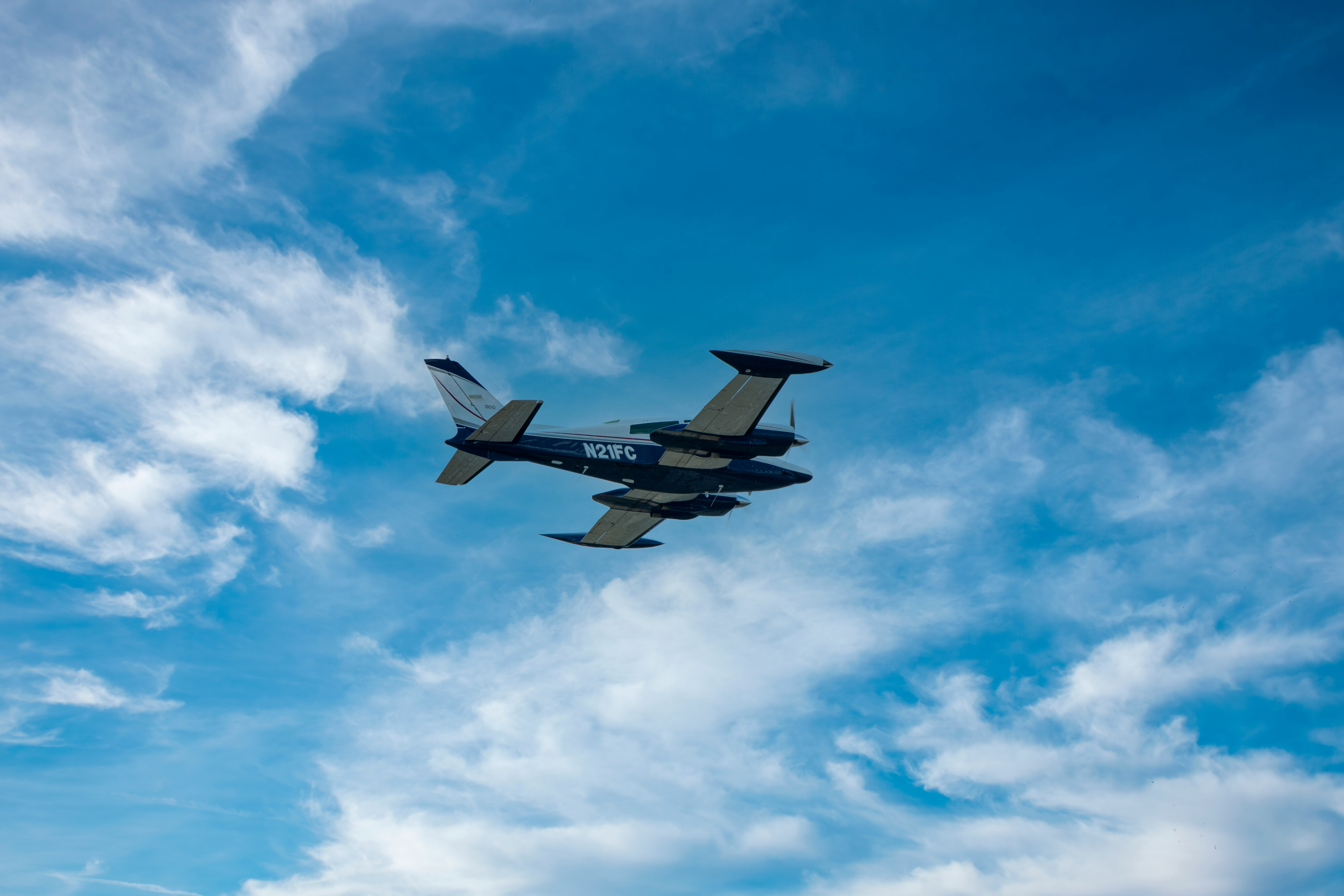 black jet plane in mid air under blue sky during daytime