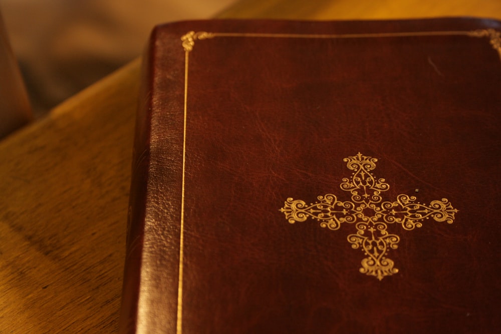 brown and gold book on brown wooden table