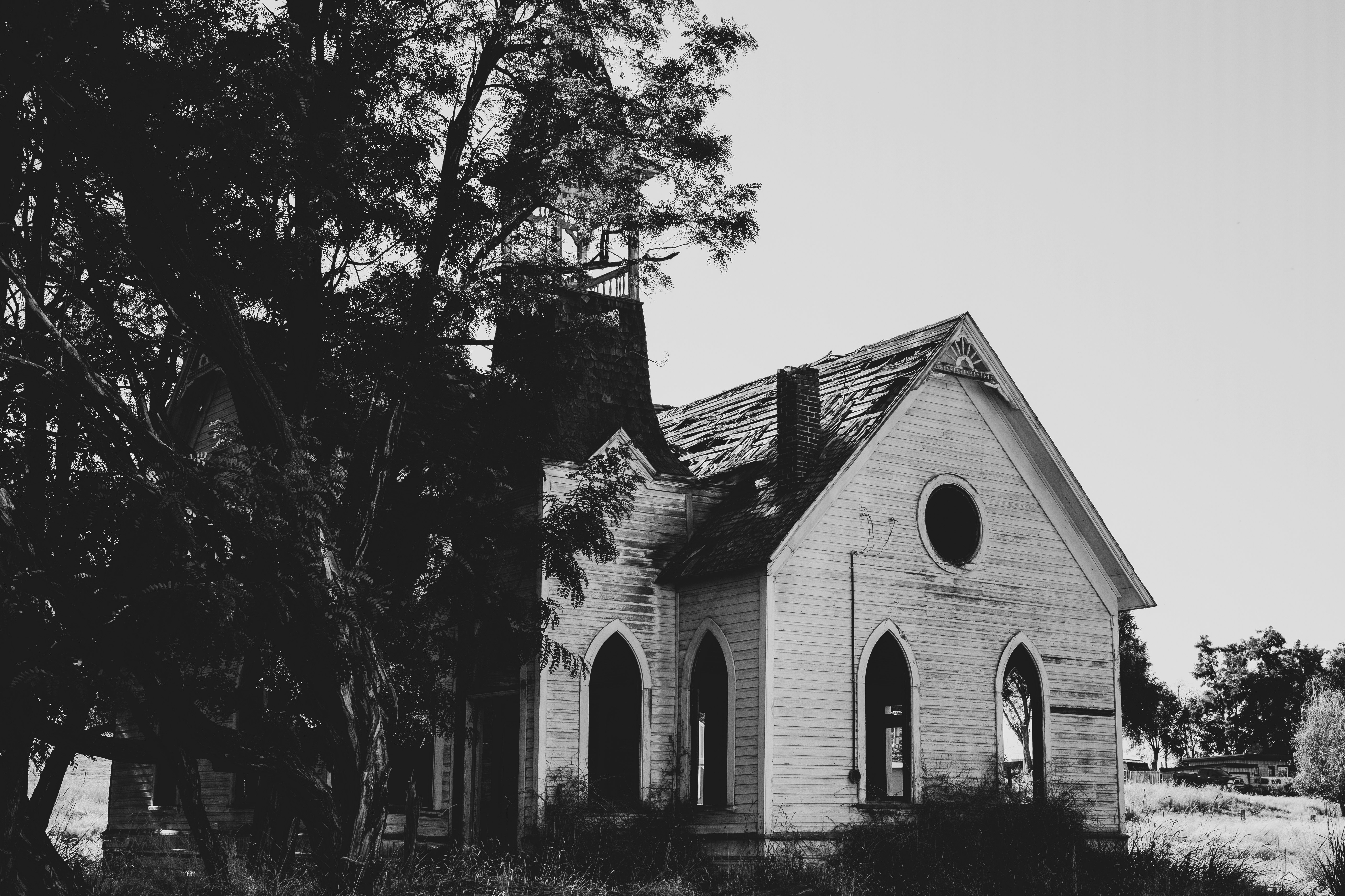 grayscale photo of a house near trees