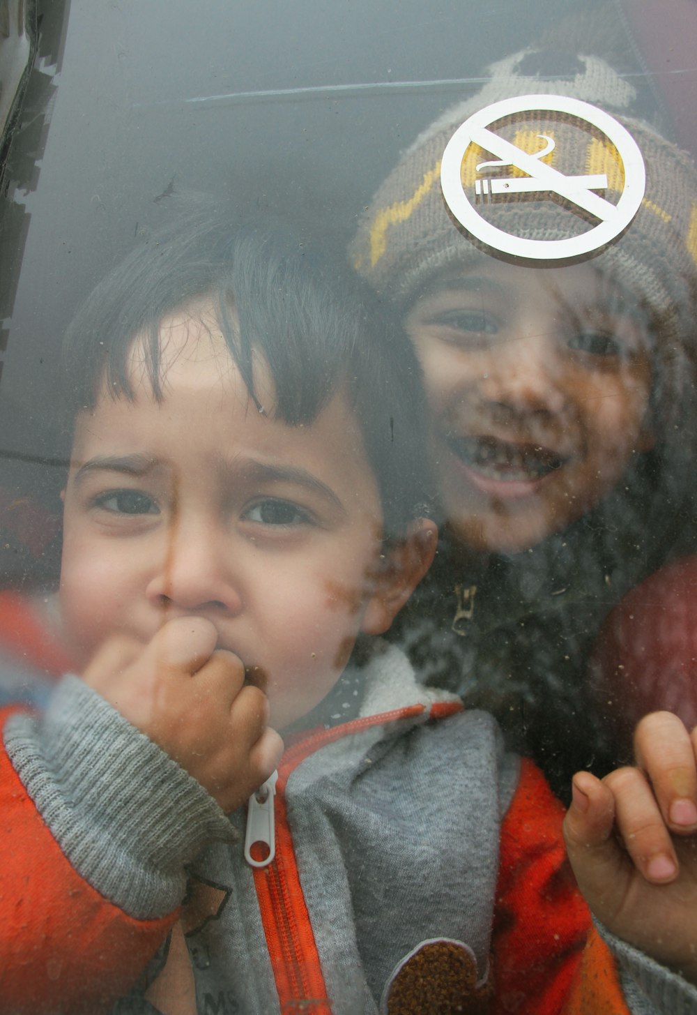 2 garçons souriant et faisant signe de paix