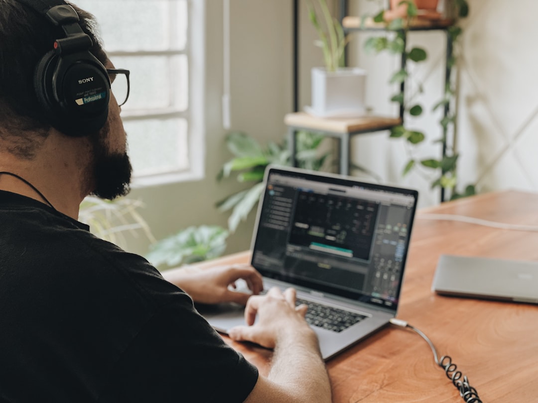 man in black shirt using macbook pro