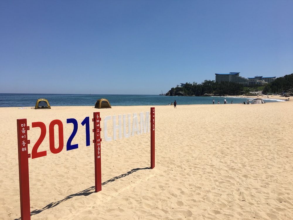 red and white beach signage on beach during daytime