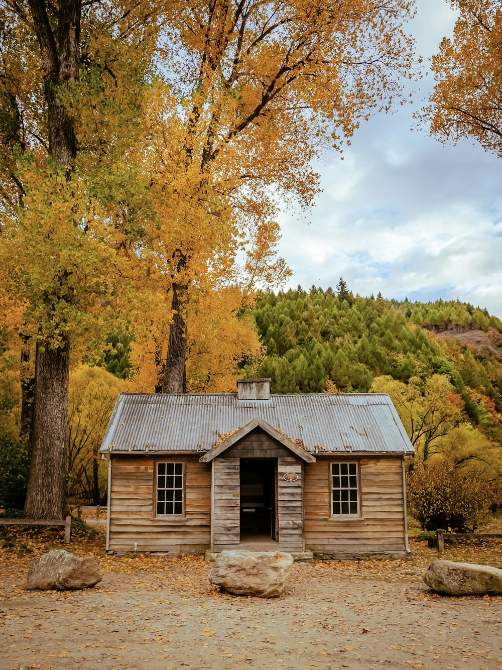 brown wooden house near green trees during daytime