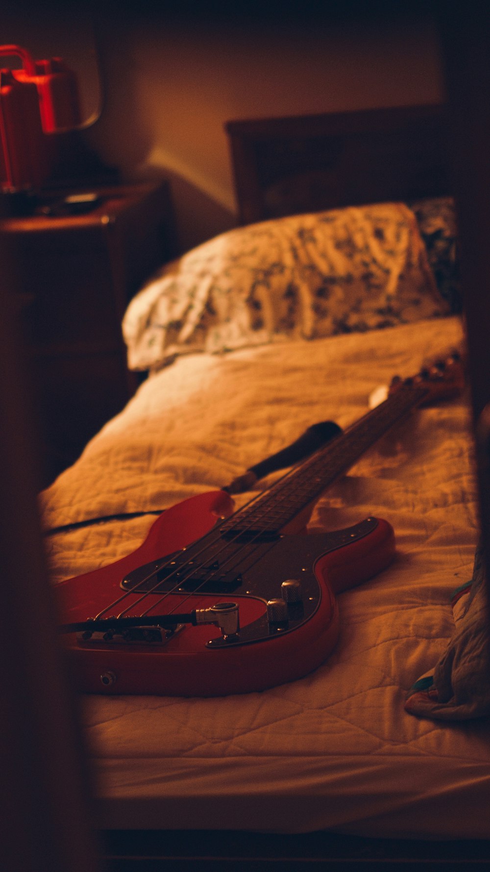Chitarra elettrica Stratocaster marrone e bianca su divano marrone