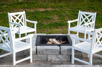 white wooden chairs on green grass field during daytime