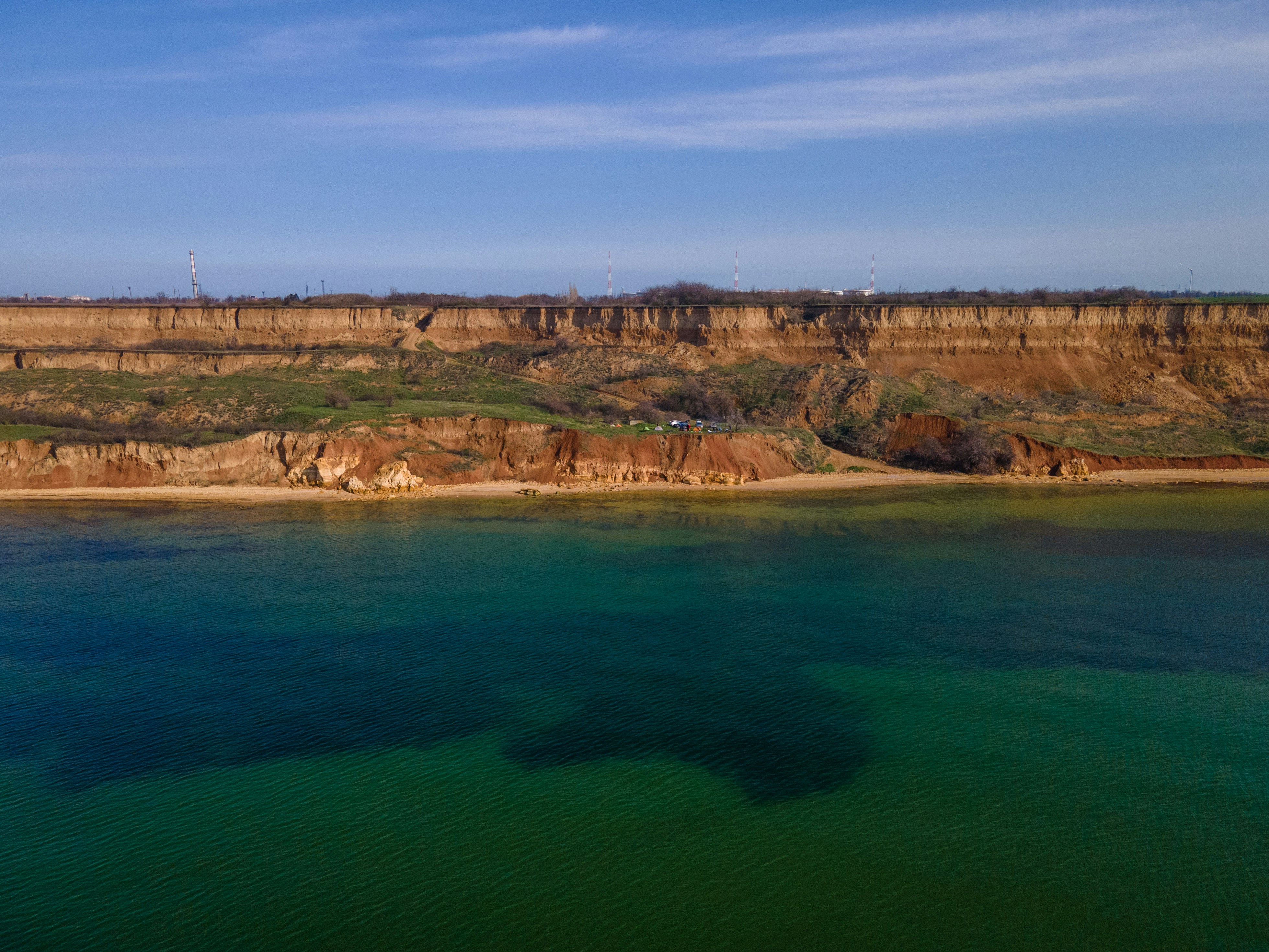 body of water near brown mountain under blue sky during daytime