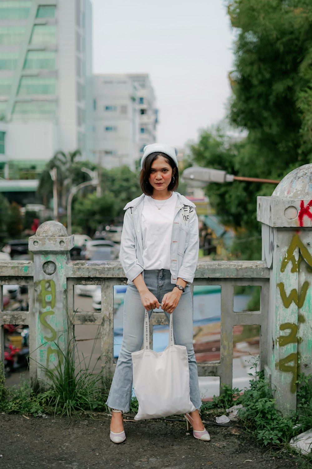 woman in white long sleeve shirt and white skirt standing on wooden bridge