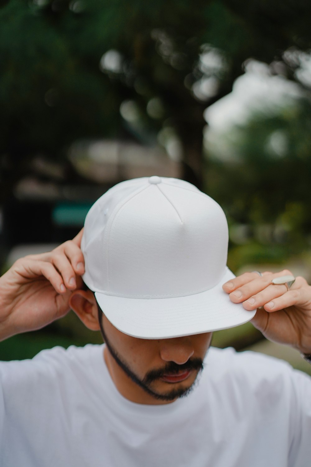 person in white long sleeve shirt holding white hat