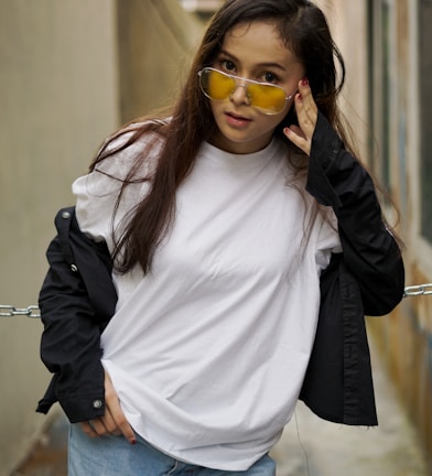 woman in white crew neck shirt and black jacket wearing sunglasses