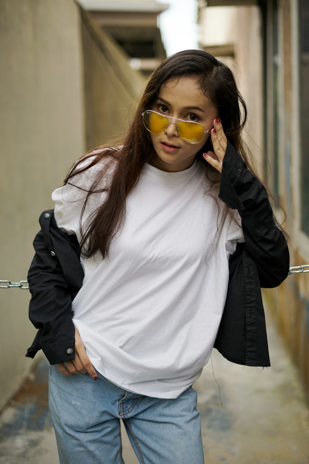 Mujer con camisa blanca de cuello redondo y chaqueta negra con gafas de sol