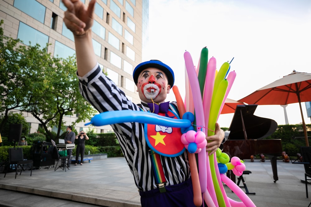 man in black white and red striped shirt holding purple balloon