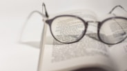 black framed eyeglasses on white book page