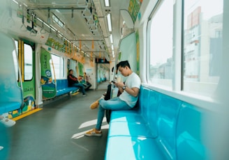 woman in white shirt sitting on blue train seat