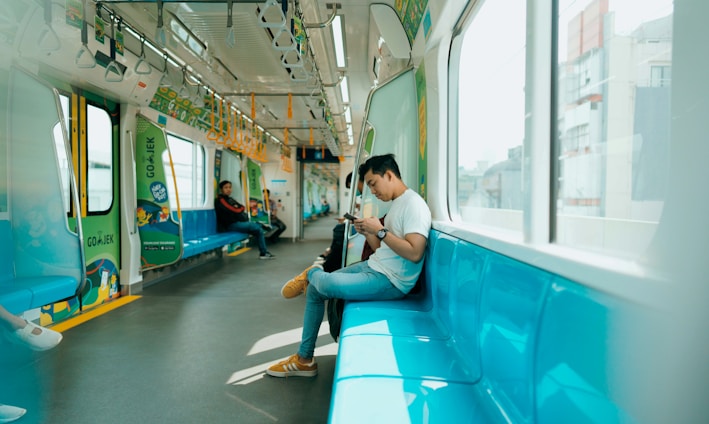 woman in white shirt sitting on blue train seat