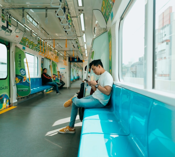 woman in white shirt sitting on blue train seat