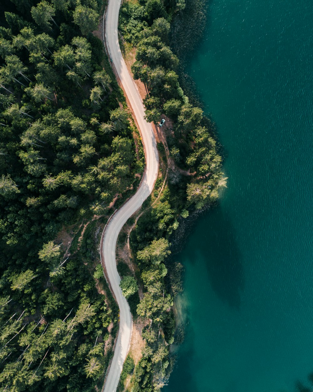 vista aérea da estrada ao lado do corpo de água durante o dia